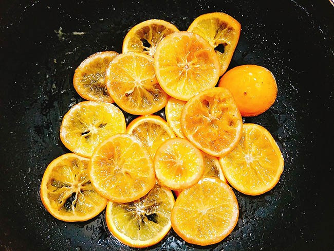 Trước khi bắt đầu làm, phải sơ chế nguyên liệu. Đầu tiên đem cam rửa sạch, luộc với nước đang sôi có chút muối khoảng 2 -3 phút là tắt bếp. Sau khi luộc xong bạn vớt cam ra ngâm vào nước đá lạnh 1 phút. Sau đó, thái cam thành từng miếng miếng dày 1 cm.