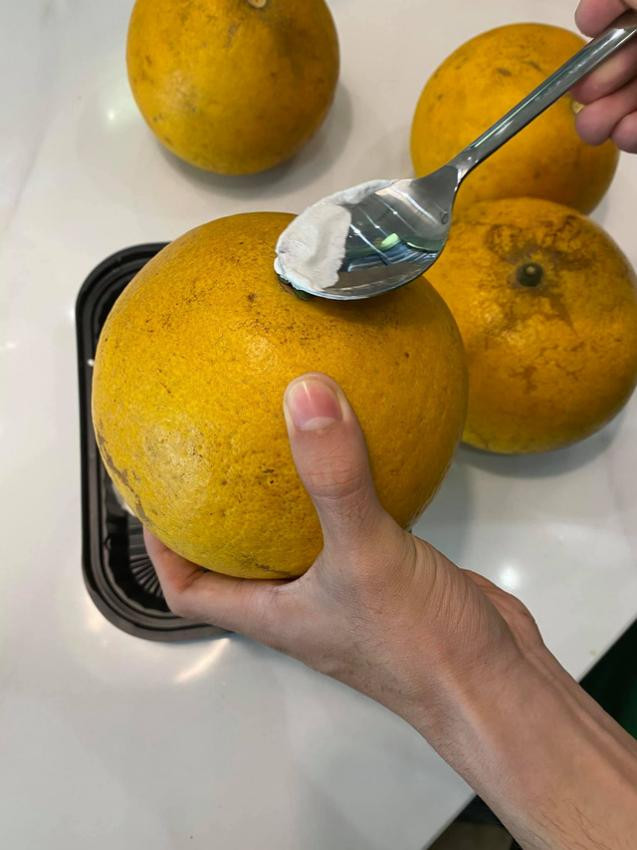 Đầu tiên, mua bưởi về, rửa sạch lau khô, nhất là phần cuống, nếu bị ẩm vài hôm sẽ thối ngay. Lau xong thì lấy khăn, thấm 1 ít rượu, lau xung quanh quả bưởi. Sau 3-4 ngày lau, thì bưởi sẽ lên màu vàng đậm hơn bình thường, rất đẹp.