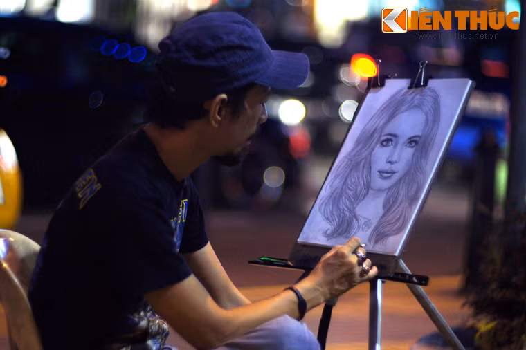 Hình ảnh họa sĩ vẽ kí họa trên vỉa hè gợi nhớ đến khu phố cổ ở Hà Nội.