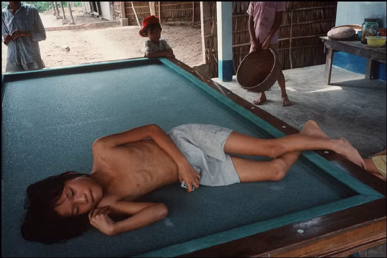 Cậu bé ngủ trên bàn billiard. Ảnh: Harry Gruyaert - Magnumphotos.com