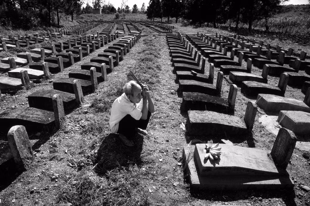 Ông Nguyễn Văn Túc viếng mộ người con trai hi sinh trên đường Trường Sơn năm 1972, khi 22 tuổi. Ảnh: Philip Jones Griffiths - Magnumphotos.com