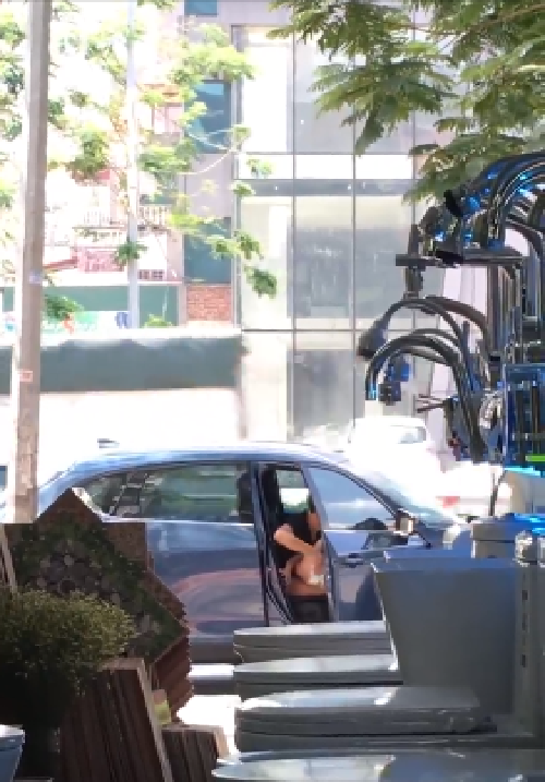 Mẹ trẻ vô tư cho con đi vệ sinh trước cửa hàng của người khác. Ảnh cắt từ clip.