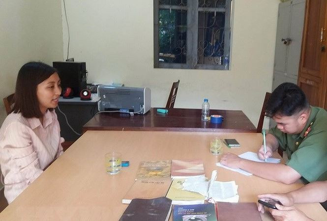 Đối tượng Nguyễn Thị Ánh Nguyệt cùng các tài liệu, vật dụng liên quan đến sinh hoạt, truyền đạo trái phép tại cơ quan chức năng. Ảnh: Xuân Tiến/TTXVN.