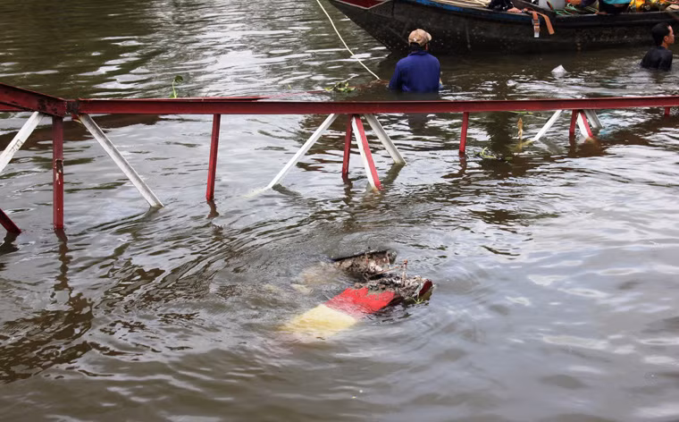 Lực lượng công nhân dầm dưới lòng sông để cắt, vớt sắt thép cầu bị gãy chìm dưới nước.