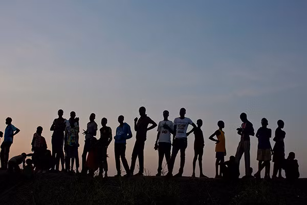 Những em bé trai xem đá bóng tại khu trại Bentiu. Được biết, 105 nghìn người đang "lánh nạn" trong trại tị nạn này.