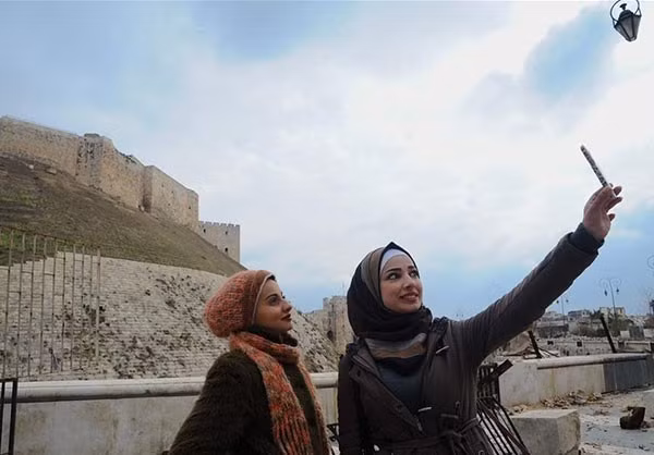Hai người phụ nữ chụp ảnh “tự sướng” trong thành phố cổ Aleppo vừa được giải phóng.