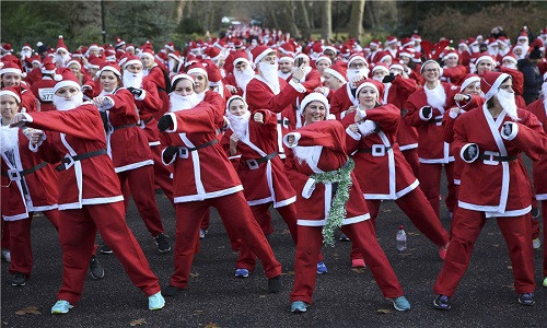 Những người tham gia khởi động để làm ấm cơ thể trước khi bước vào cuộc thi chạy Santa Run ở công viên Battersea, London, ngày 3/12. Ảnh: China Daily.