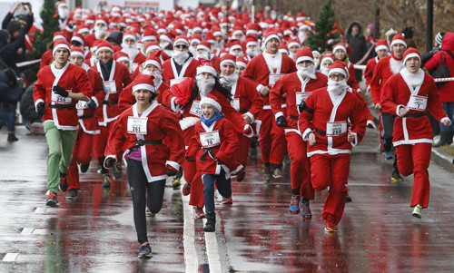 Người dân trong trang phục Ông già Noel kiểu Mỹ và Ông già mùa Đông (Father Frost) kiểu Nga chạy trong chương trình "Happy Run" gây quỹ từ thiện giúp đỡ trẻ em mắc bệnh hiểm nghèo ở thủ đô Moskva, Liên bang Nga.