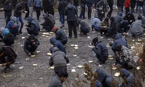 Những người tị nạn được lực lượng tình nguyện phân phát bữa ăn miễn phí.