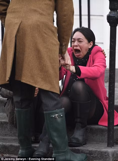 Người phụ nữ hoảng sợ ngồi khóc bên ngoài một ngôi nhà ở Islington. (Nguồn ảnh: Daily Mail).