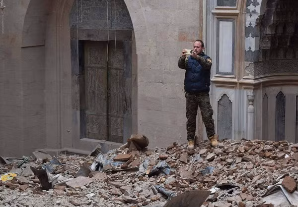 Một người đàn ông Syria ghi lại cảnh tượng đổ nát ở Aleppo.
