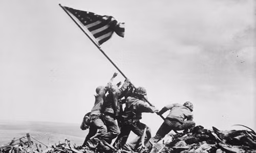 5 lính thủy quân lục chiến Mỹ và 1 thủy thủ giương cờ Mỹ trên núi Suribabachi trong trận đánh Iwo Jima ngày 23/2/1945. Theo Wikipedia, trận Iwo Jima diễn ra từ ngày 19/2 đến ngày 26/3/1945 là trận đánh thuộc mặt trận Thái Bình Dương trong Chiến tranh Thế giới thứ 2 giữa Mỹ và Nhật Bản tại đảo Iwo Jima.
