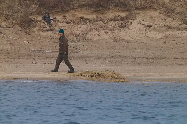 Một người dân Triều Tiên ngoái đầu nhìn trên bờ sông Áp Lục.