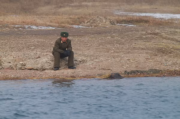 Binh sĩ Triều Tiên ngồi bên bờ sông.