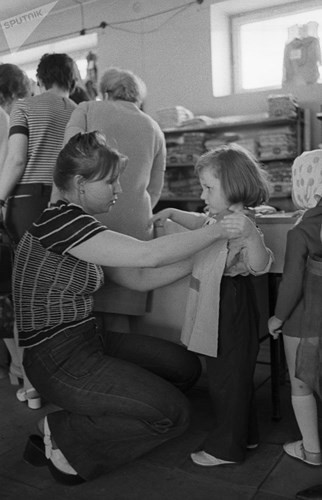 Một bà mẹ dẫn con đi mua đồ tại Thế giới Trẻ em năm 1973.