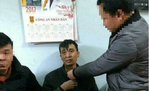 Nghi phạm (giữa) tại cơ quan công an.