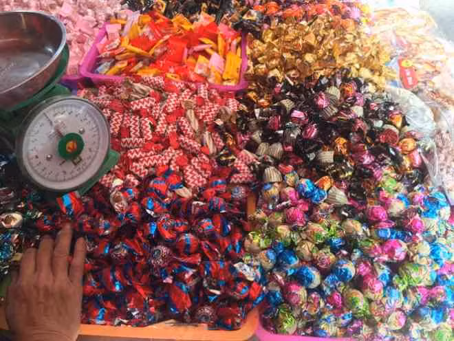 Ngoài mứt, bánh kẹo cân cũng được bày bán song song, không bao bì, không hạn sử dụng. Người bán giải thích, bánh kẹo đóng thùng 5kg nên khi bóc lẻ ra bán không còn bao bì gốc