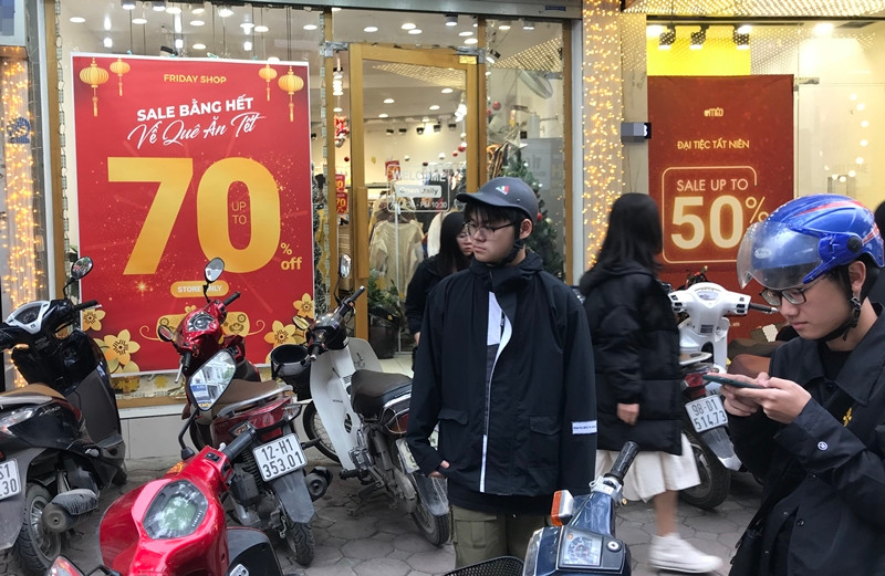 Khá nhiều khách hàng nam bên cạnh nữ đi mua quần áo Tết ở các cửa hàng thời trang đang giảm giá trên đường Cầu Giấy.