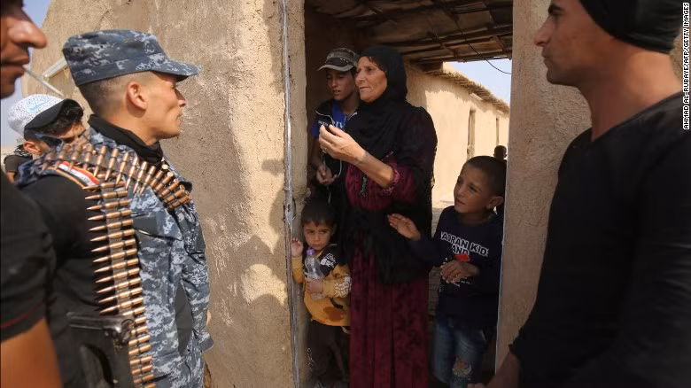 Các binh sĩ Iraq trò chuyện với một gia đình ở ngôi làng al-Khuwayn sau khi phiến quân IS bị đánh bật khỏi đây.