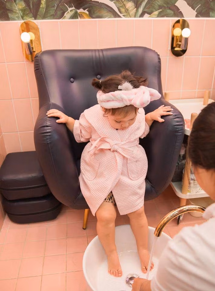 Cô bé tỏ ra vô cùng thích thú khi được các cô nhân viên massage thư giãn nên ngồi im để hưởng thụ.