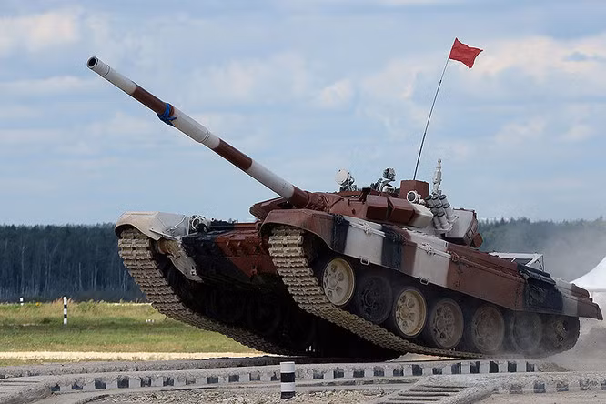 Cuộc chiến xe tăng Tank biathlon gồm các nội dung chính: Các tay lái xe tăng sẽ phải chạy 3 vòng 6-10km. Trong vòng đầu, kíp xe sẽ phải bắn mục tiêu ở khoảng cách 1.800, 1.700 và 1.500 mét. Trong vòng 2, kíp lái sẽ phải đối phó với mục tiêu giả định tiểu đội mang súng chống tăng đang nhắm vào. Mục tiêu nằm ở khoảng cách 600-700m và phải sử dụng súng máy 7,62mm PKT tiêu diệt. Ở vòng 3, các kíp lái tăng sẽ phải đối phó với mục tiêu dạng kẻ địch dùng tên lửa chống tăng ngắm băn, họ phải sử dụng đại liên 12,7mm để tiêu diệt ở khoảng cách 1.200m. Vòng cuối, cùng là các xe tăng phải vượt qua nhiều đội hình mấp mô gồm cả hồ nước, các chướng ngại vật lớn... Ảnh: Xe tăng T-72B3 của đội Mông Cổ đang vượt qua chướng ngại ở vòng cuối.