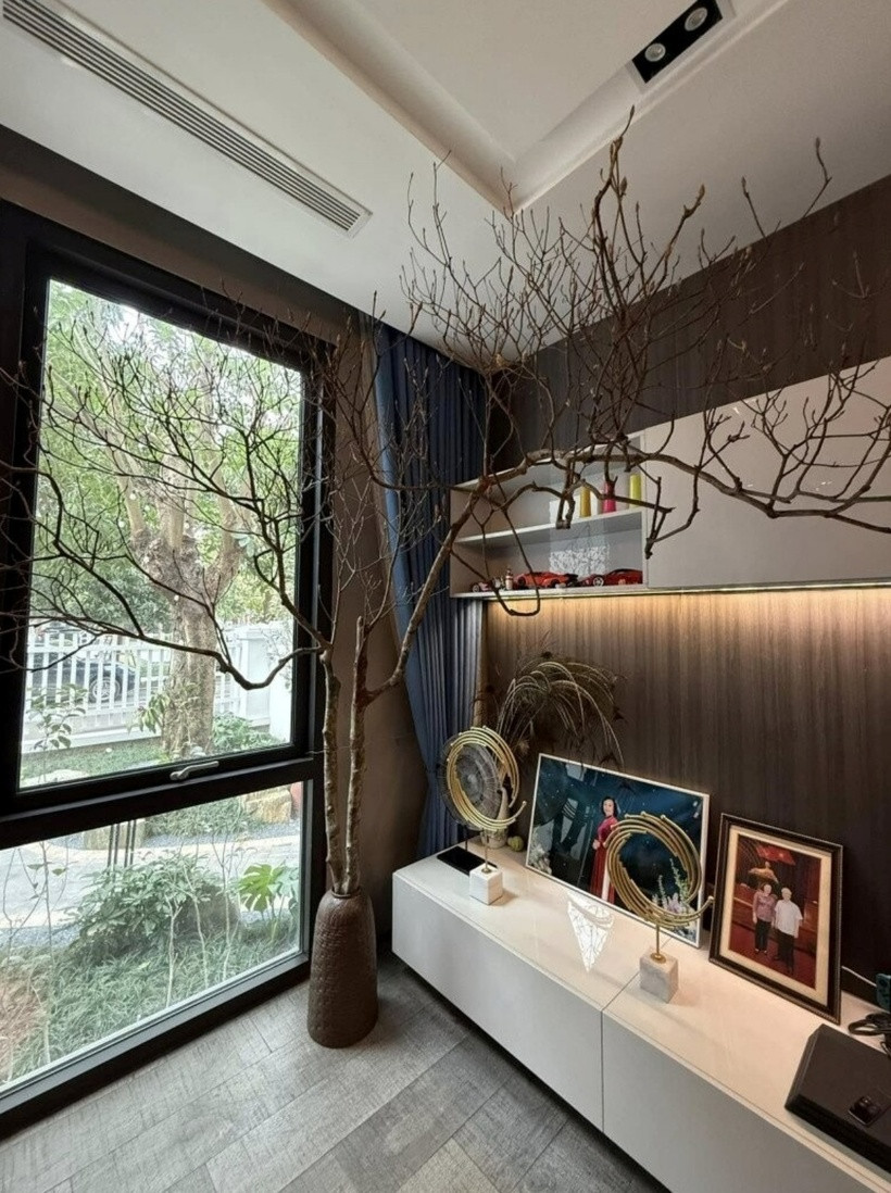 Phòng khách có tông màu trầm ấm, kết hợp giữa gỗ và ánh sáng gián tiếp tạo nên sự sang trọng.