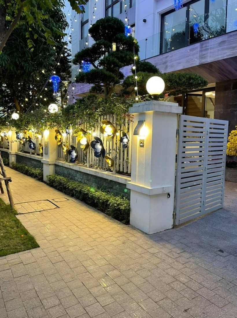 Anh chăng đèn kết hoa cho căn biệt thự từ ngay cổng vào. Ngoài ra, mọi ngóc ngách đều được tô điểm với đủ các chậu hoa lớn, nhỏ như đào, mai, đồng tiền... nhìn là thấy rộn rã sắc xuân.