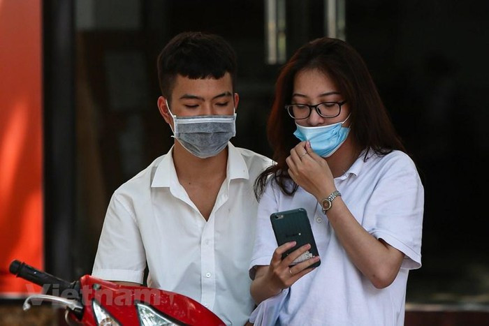 Bên cạnh những niềm vui thì sự lo lắng vẫn len lỏi trong nhiều thí sinh khi hoàn thành chưa tốt. Nhiều em ngay lập tức so đáp án khi ra về. (Ảnh: Phúc Tá/Vietnam+)