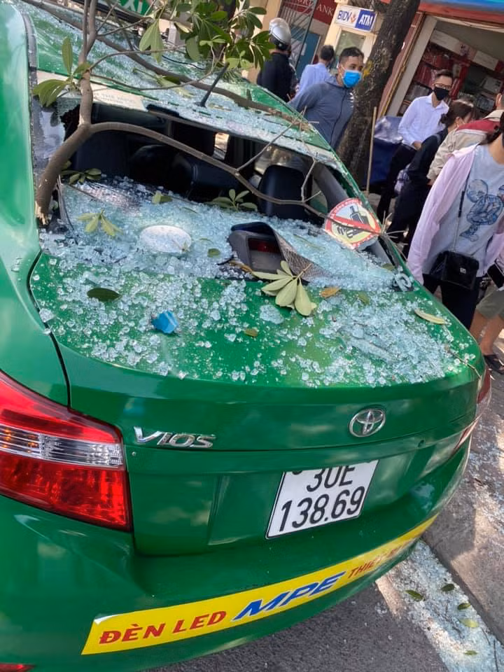 Cũng tại hiện trường một chiếc taxi bị vỡ kính sau do cành cây, kính trên căn nhà này rơi xuống.