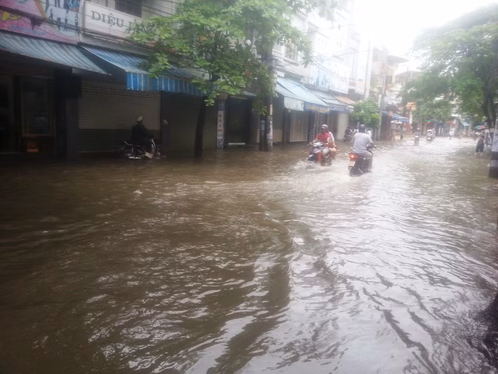 Nước ngập sâu khiến người dân đi lại rất khó khăn.