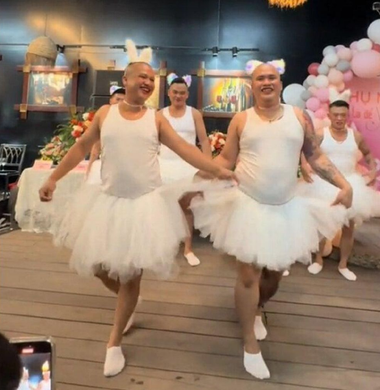 Trong đoạn clip, các nam vũ công này diện váy phồng màu trắng, dắt tay nhau cùng trình diễn tiết mục múa ba lê "Hồ thiên nga" nổi tiếng.