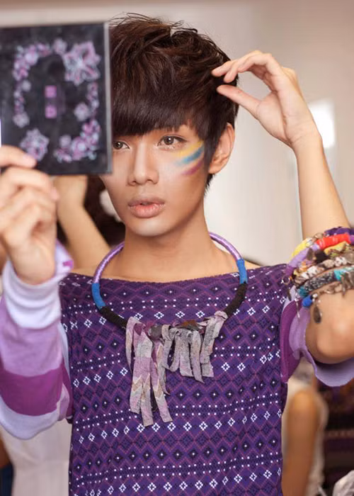 Giọng ca bước ra từ cuộc thi The Voice 2012 một tay cầm gương một tay chỉnh sửa tóc để có vẻ ngoài chỉn chu nhất. Ảnh: FBNV