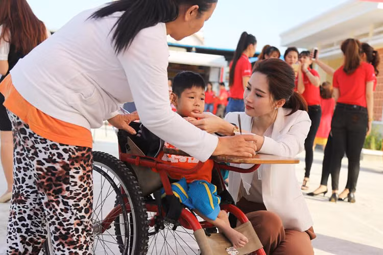 Hoa hậu Việt Nam 2012 còn nhẹ nhàng, khéo léo trong cách cư xử. Trong ảnh, cô ân cần hỏi han các em nhỏ trong một chuyến thiện nguyện. Ảnh: FBNV