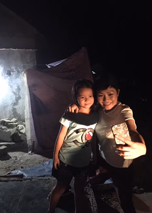 Phương Thanh thân thiện chụp ảnh cùng một người hâm mộ nhí trong chuyến đi từ thiện ở Hà Tĩnh.