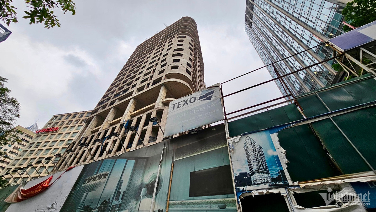 Giàn thép hoen gỉ, nhiều biển bảng quảng cáo cũ rách.