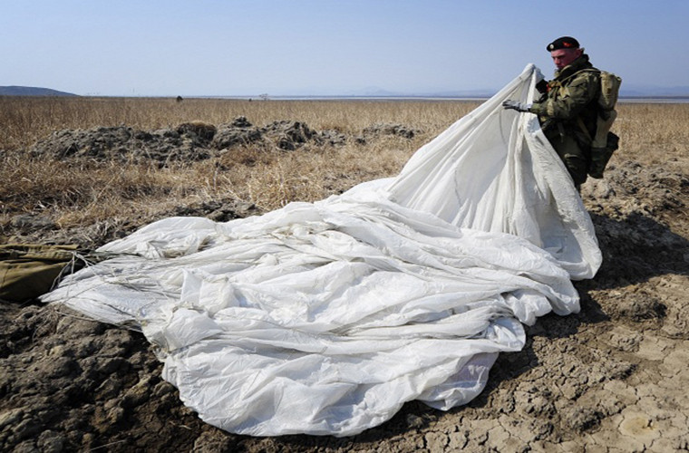 Trong ảnh là một lính thủy đánh bộ Nga thu lại dù của mình sau khi tiếp đất an toàn.