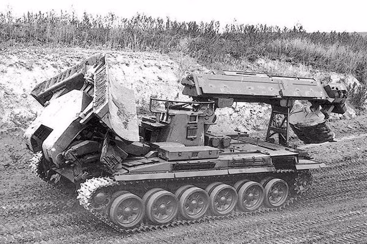 Trong khi đó, phía trước của IMR-2 được trang bị hệ thống lưỡi ủi thủy lực giúp loại bỏ và san bằng các vật cản trên mặt đất. Điểm đặc biệt là lưỡi ủi của IMR-2 có thể được gấp lại theo hình chữ V hoặc giữ thẳng tùy theo yêu cầu của từng loại địa hình khác nhau.