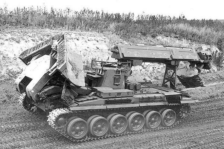 Trong khi đó, phía trước của IMR-2 được trang bị hệ thống lưỡi ủi thủy lực giúp loại bỏ và san bằng các vật cản trên mặt đất. Điểm đặc biệt là lưỡi ủi của IMR-2 có thể được gấp lại theo hình chữ V hoặc giữ thẳng tùy theo yêu cầu của từng loại địa hình khác nhau.