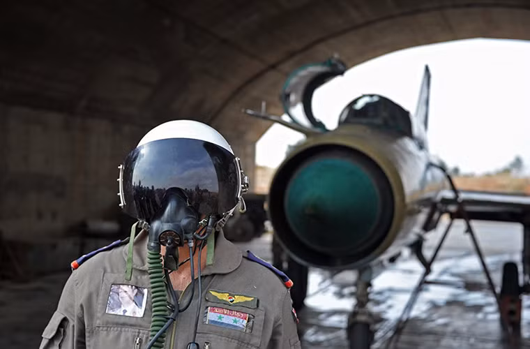 Trong ảnh là một phi công lái máy bay chiến đấu thuộc Không quân Syria với chiếc MiG-21 của mình.