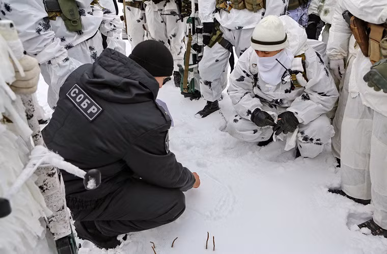 Hình ảnh một sĩ quan chỉ huy của chương trình huấn luyện hướng dẫn cho các tay súng bắn tỉa một số lưu ý trước khi bắn.