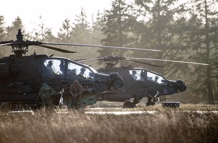 Hai chiếc Apache AH-64 nạp lại đạn tại một sân bay dã chiến trước khi cất cánh cho một đợt bay mới.