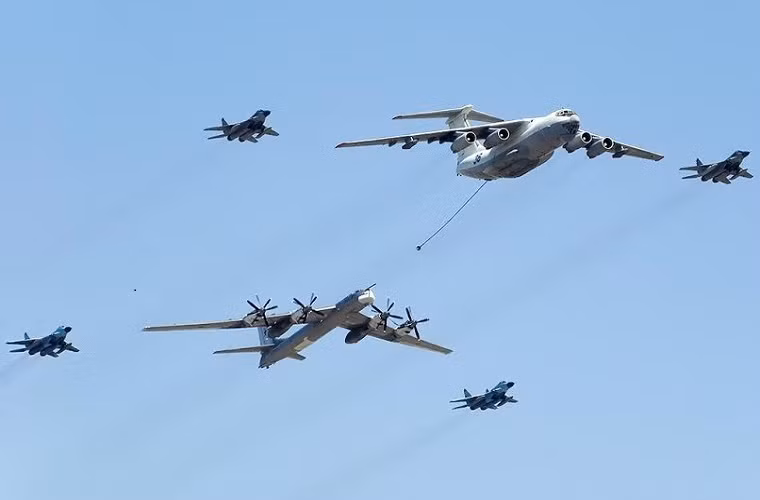 Trong ảnh là biên đội gồm máy bay ném bom chiến lược tầm xa Tu-95, máy bay tiếp nhiên liệu trên không IL-78 cùng phi đội tiêm kích MiG-29 của Không quân Nga.