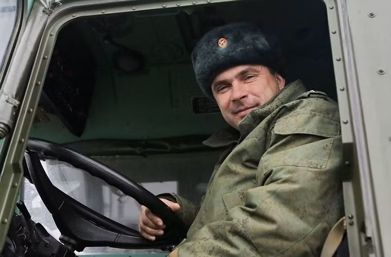 Nụ cười của một binh sĩ Nga trên chiếc MAZ-7917 của mình sau khi hoàn thành phần thi của mình trên hệ thống đường mô phỏng.