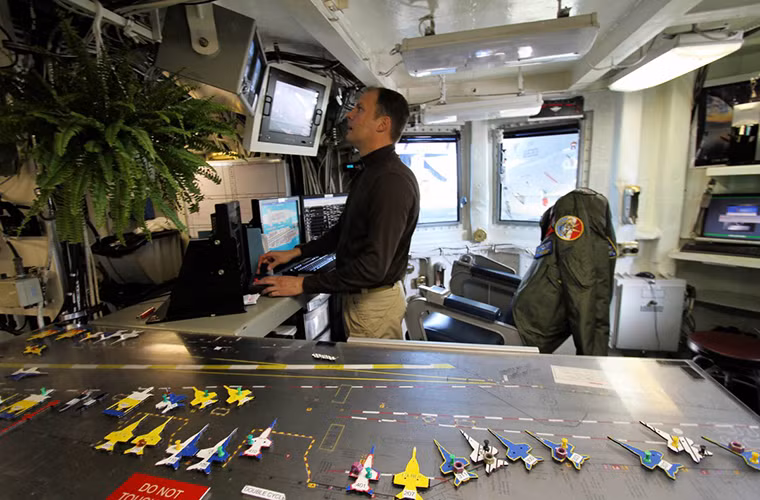 Không khí bên trong trung tâm điều hành bay trên tàu sân bay Mỹ mang tên USS Eisenhower luôn tấp nập như chính trên boong tàu của nó. Toàn bộ hoạt động trên một tàu sân bay đều được thực hiện thông qua tháp chỉ huy và trung tâm điều khiển bay của nó.
