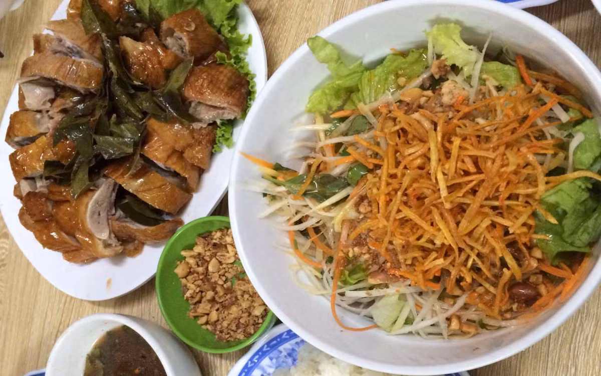 Khi nguyên liệu đã sơ chế xong, xếp lần lượt một lớp bánh phở nếu mùa đông bánh phở được nhúng qua nước sôi cho nóng, sau đó đến xá xíu, dưa chuột và lạc rang, khoai lang chiên, hành khô lên trên. Tùy khẩu vị, thực khách có thể thêm chút chanh tươi, ớt hay tiêu. Ảnh Internet