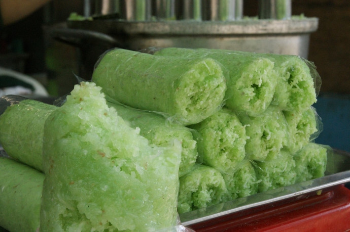  Bánh cuốn ống lá dứa: Bánh cuốn ống lá dứa được làm từ các nguyên liệu đơn giản như: hỗn hợp nếp, dừa nạo, đậu xanh, đường cát, sau đó được người làm bánh khéo léo cuộn bánh thành hình ống, có vỏ mỏng và thơm mùi lá dứa. Ngoài ra, phần nhân được làm từ dừa sợi, kết hợp lại khi ăn bánh sẽ có vị béo thơm của dừa nạo và vị ngọt bùi của đậu xanh. Bánh có giá 10.000 đồng/chiếc. Ảnh Internet