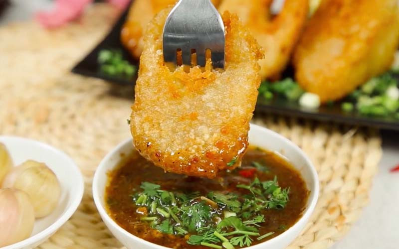 Chiên bánh chưng sao cho vàng đều, có thể thái lát để chiên cho đẹp mắt. Tiếp theo làm sốt cho vào cối 3 tép tỏi, 3 - 4 rễ rau mùi, 3 trái ớt, 1 củ gừng và 1 củ hành tím nhỏ, dùng cối giã nhuyễn hỗn hợp. Cho vào chảo 1 muỗng canh dầu ăn, mở lửa lớn để dầu sôi. Sau đó cho hỗn hợp vừa giã nhuyễn vào, đảo sơ vài cái thì cho thêm 60ml nước, 120g sốt tiêu đen, ½ muỗng canh hạt nêm vào đảo liên tục. Khi hỗn hợp bắt đầu sánh và sệt lại thì bạn cho thêm hành lá, rau mùi cắt nhỏ vào, đảo thêm vài lần là hoàn thành nước sốt. Bánh chưng giòn rụm bên ngoài, dẻo thơm bên trong kết hợp cùng với vị cay nồng của sốt tiêu đen sẽ khiến bạn không thể nào ngừng ăn. Ảnh minh họa