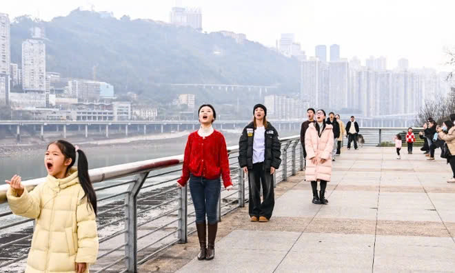 Người chụp cần kết hợp ăn ý, lựa chọn vị trí phù hợp, để bức ảnh hoặc góc quay trùng với thời điểm chuyến tàu "chui tọt" vào miệng người được chụp. Ảnh Chongqing Daily