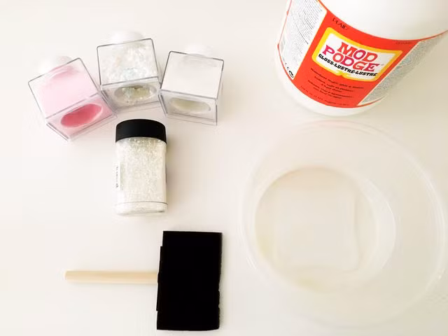 Cần chuẩn bị đầy đủ những thứ như: sơn trắng, nước, những lọ kim tuyến màu, cọ quét sơn, sơn bóng, chậu nhựa...