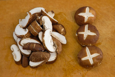 Nấm rửa sạch. Thái mỏng nấm theo từng miếng vừa ăn, một số cây nấm bạn khía hình chữ thập để trang trí ở trên.